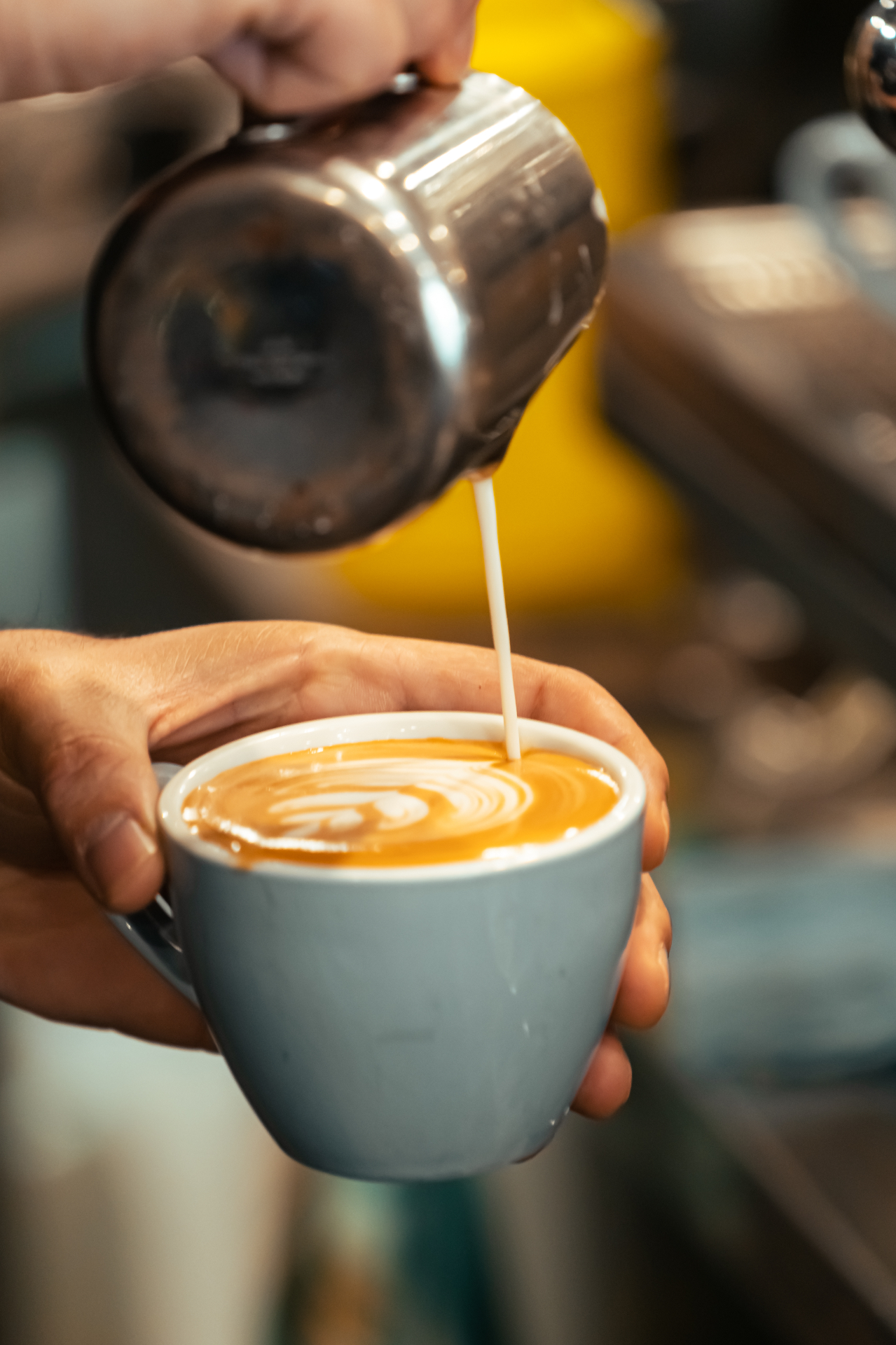 Barista pouring latte art in a Caffè Buongiorno cup